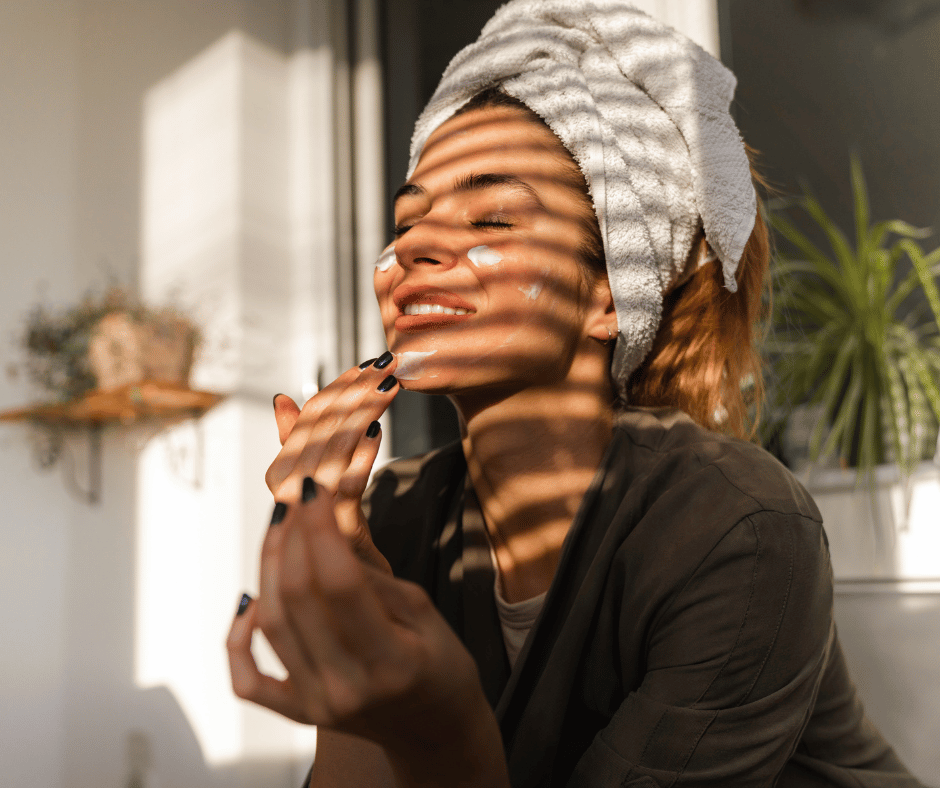 Woman doing a skincare routine in the filtered sunshine of her bathroom