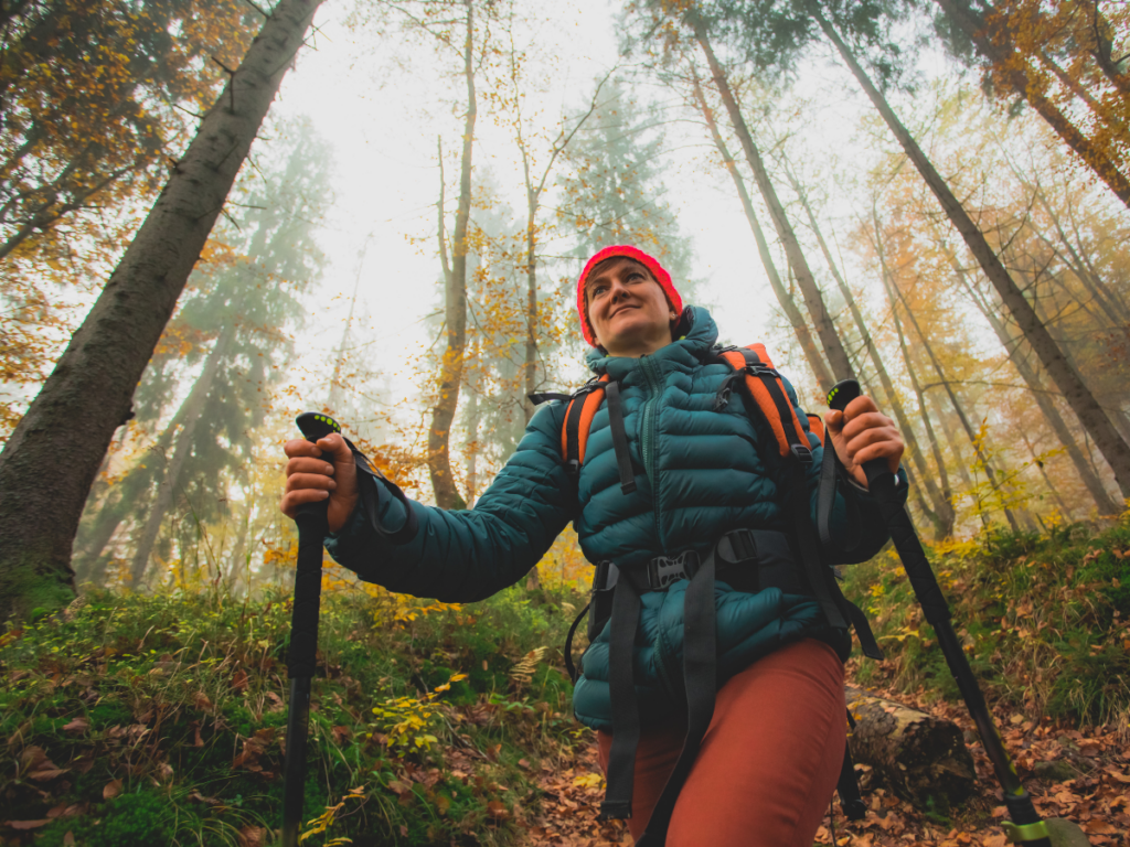 Person hiking in the forest during fall, happy